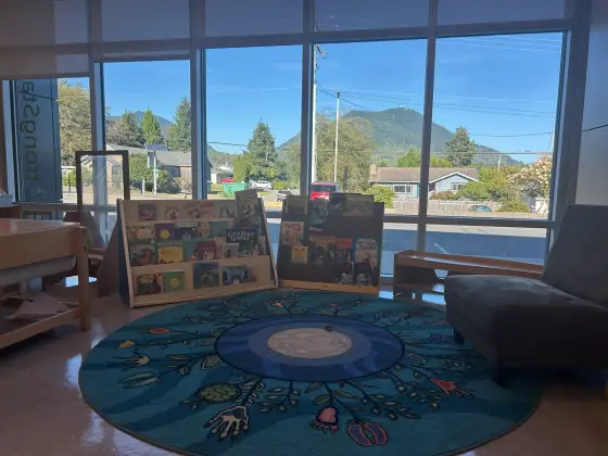 The Butterfly Room reading corner, with picture-book displays and an armchair beside floor-to-ceiling windows looking out to the mountains